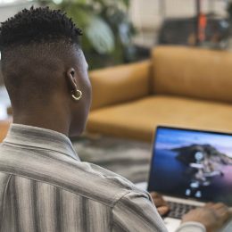 A non-binary person using a laptop at work