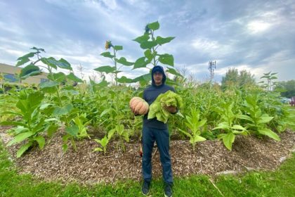 Picture of a person in a field holding a squash